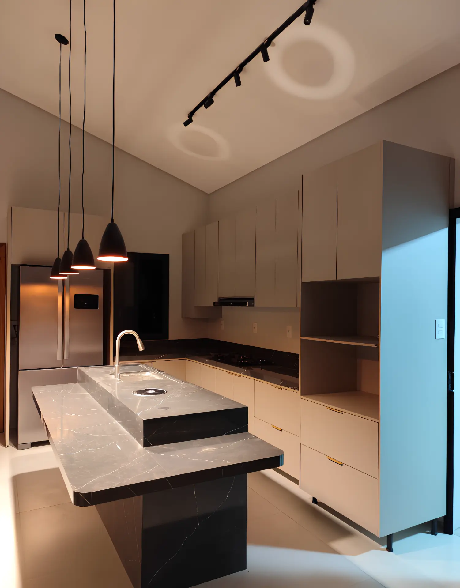 Cozinha planejada com ilha em mármore e iluminação em trilho