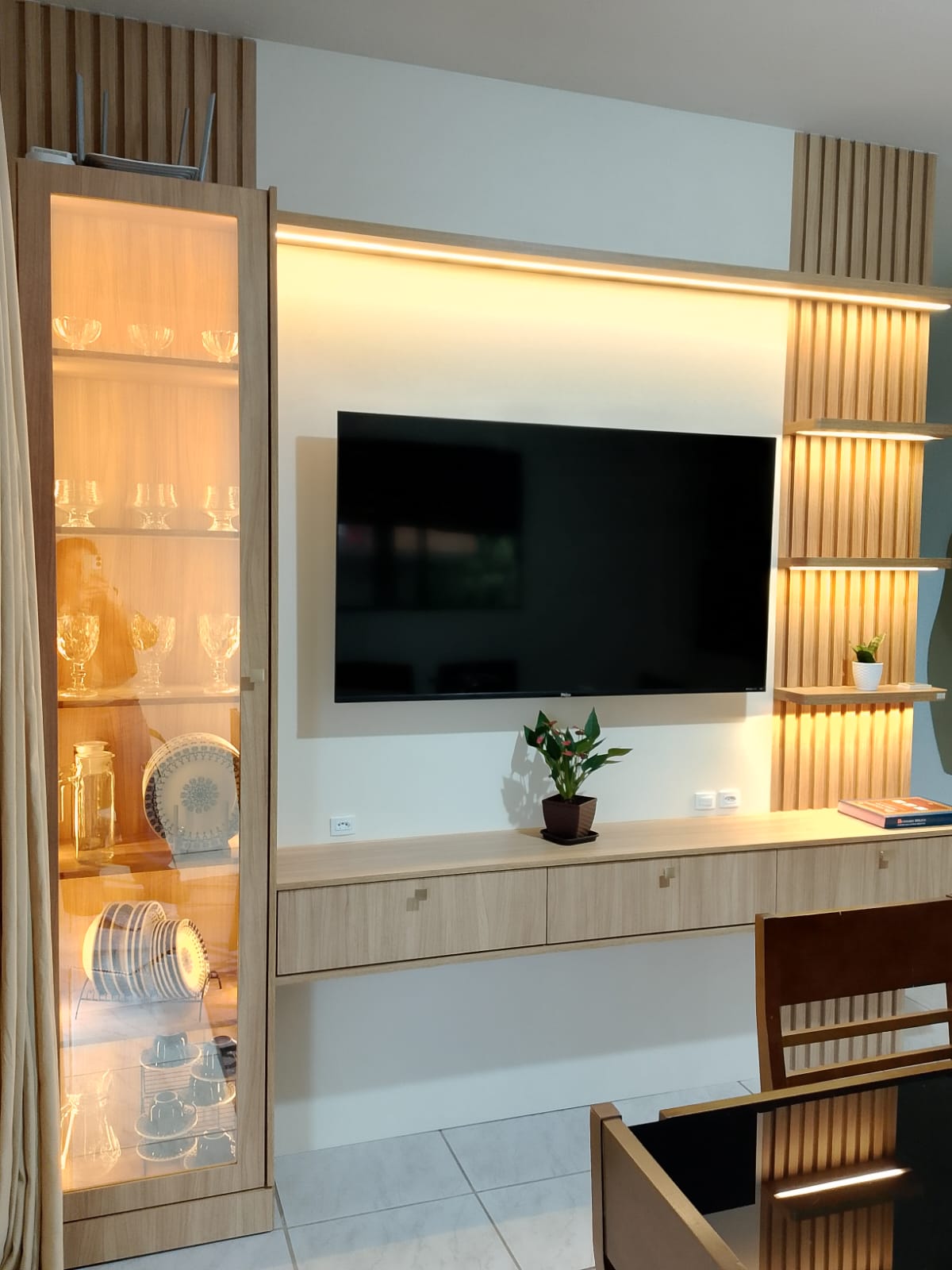 Painel de TV planejado com cristaleira e iluminação embutida
