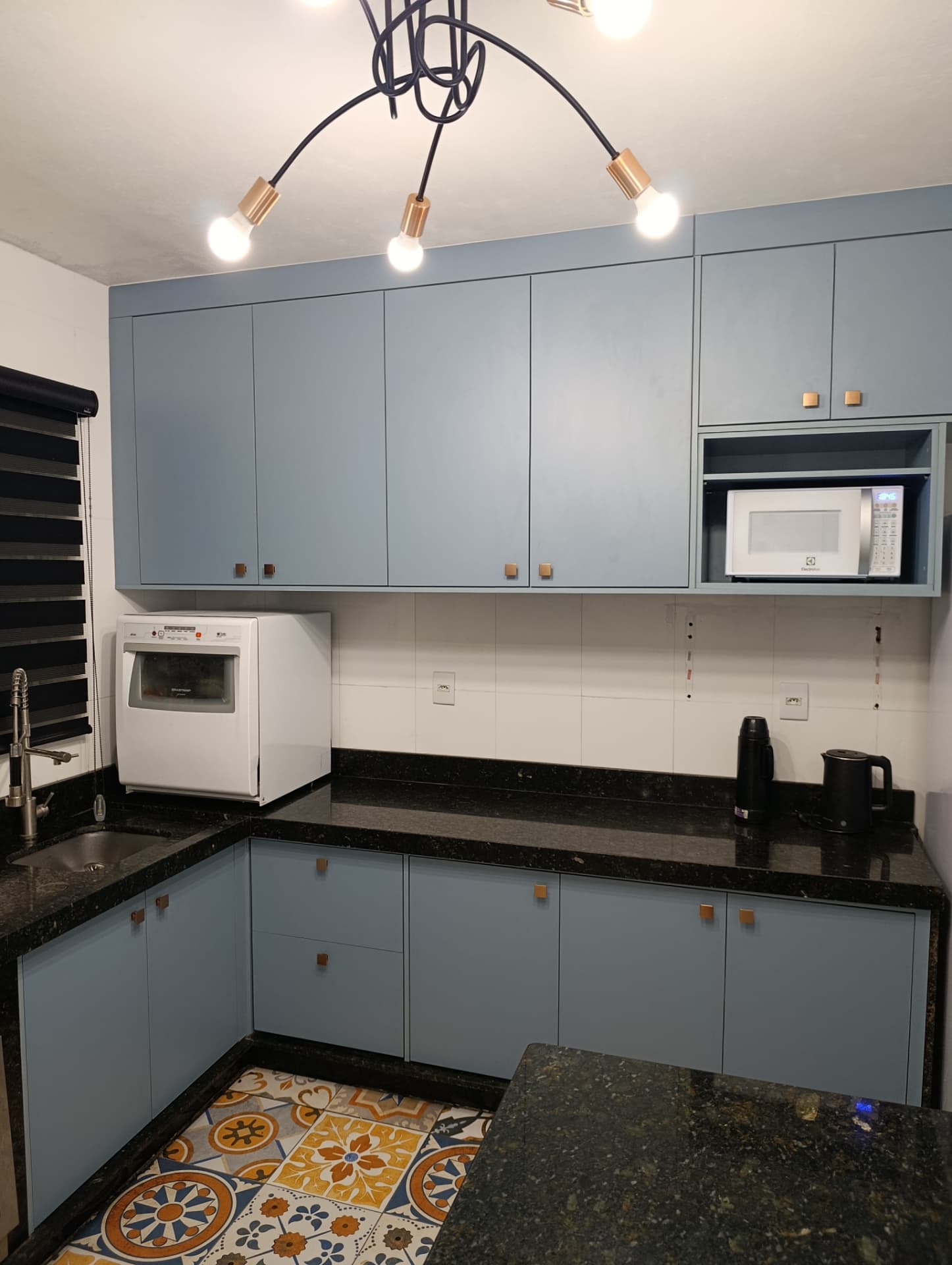 Cozinha planejada azul com bancada em granito e armários aéreos